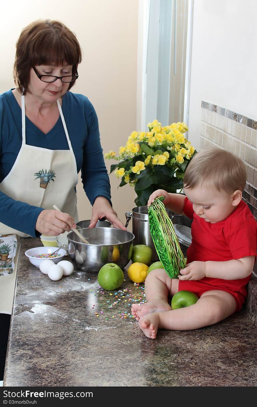 Grandmother and grandson in the kitchen baking cake. Grandmother and grandson in the kitchen baking cake