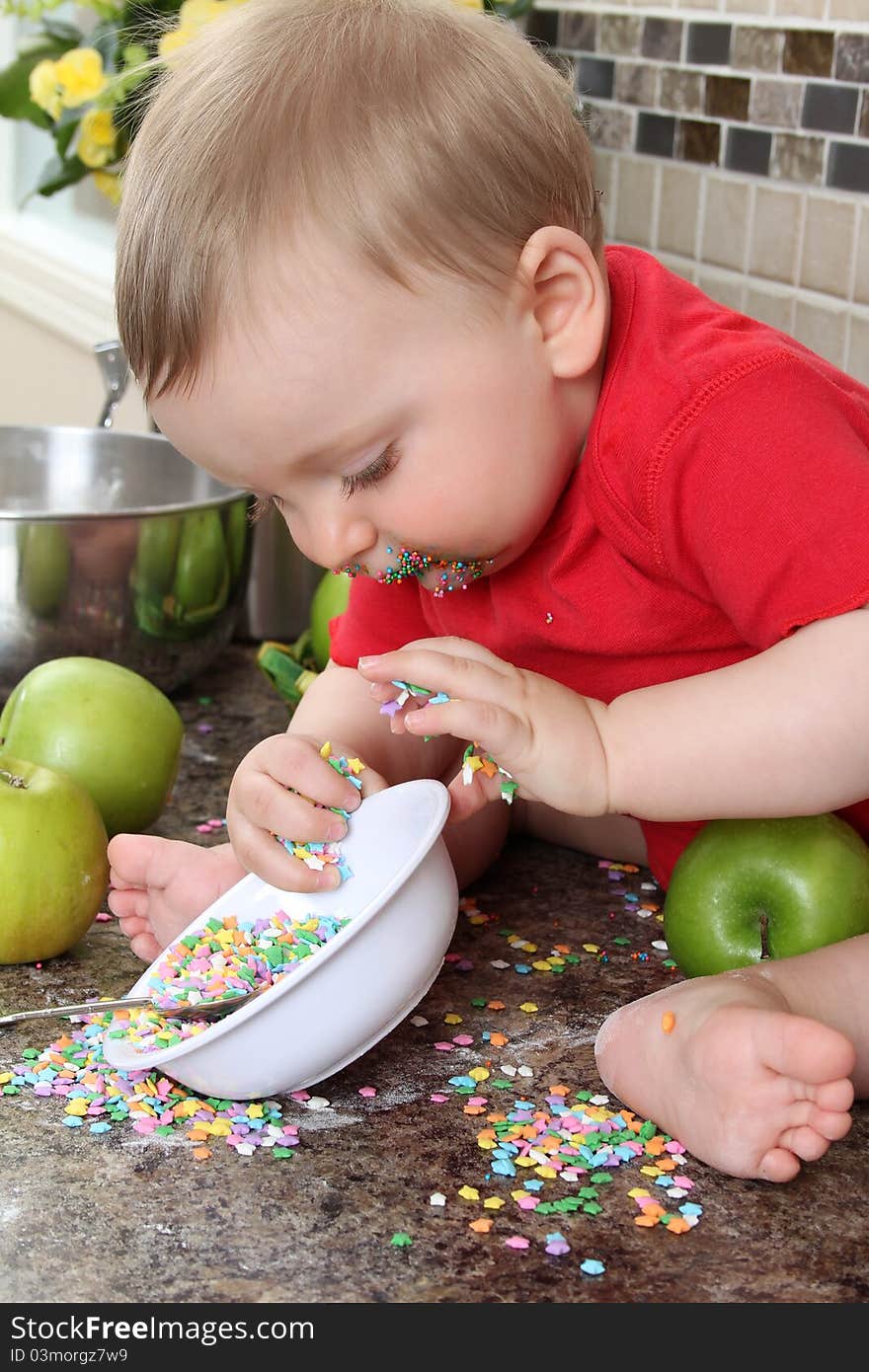 Baby boy playing on messy counter top. Baby boy playing on messy counter top