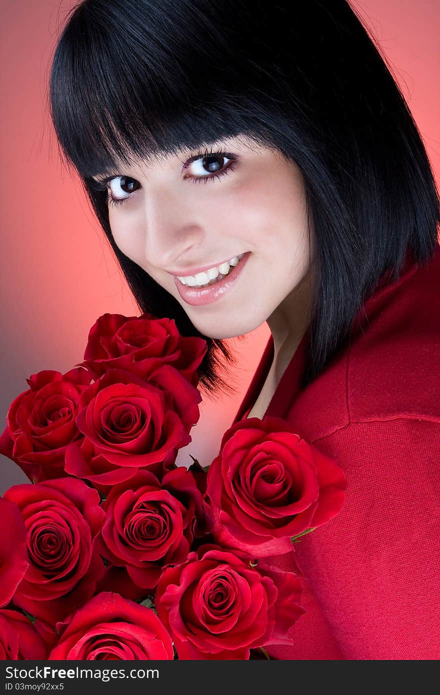 Beautiful young girl is holding a bouquet of  red roses