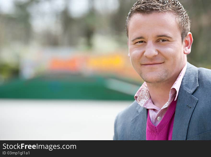 Satisfied smiling businessman. In park