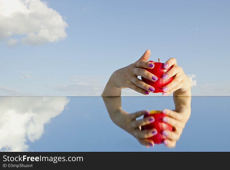 Womans hands holding red apple and mirror. Womans hands holding red apple and mirror