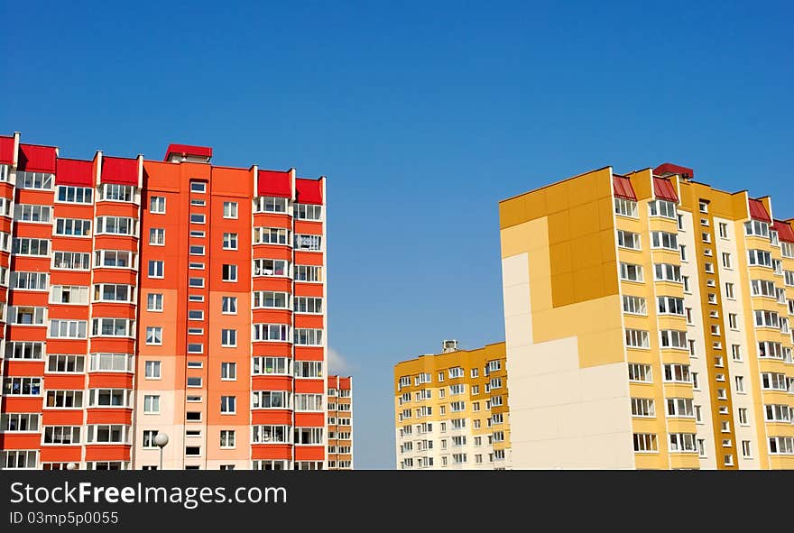 Multistory yellow and red houses on the background of blue sky