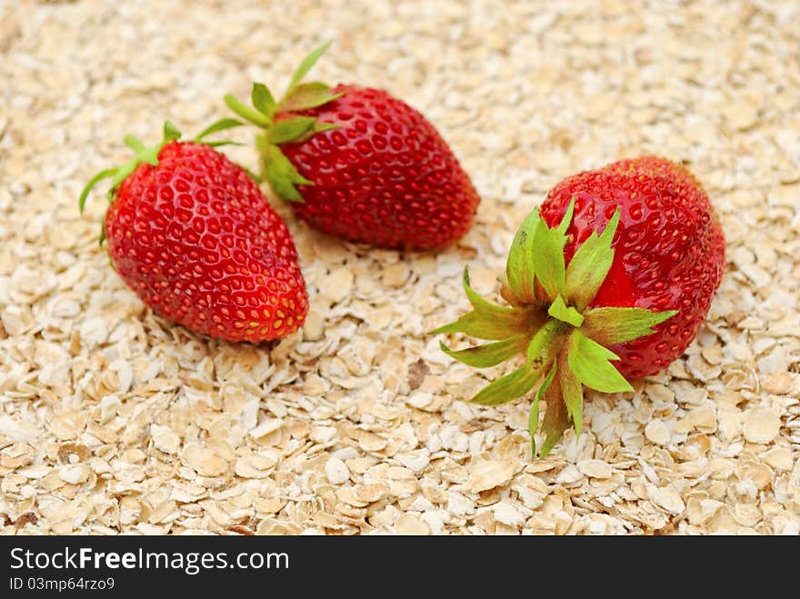 Ripe strawberries on background of dry oat, healthy eating concept