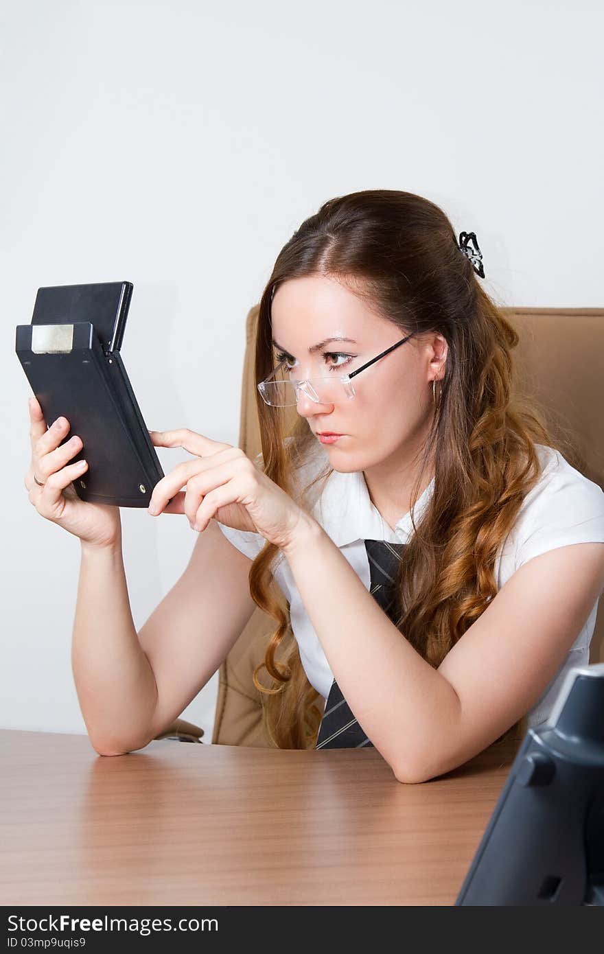 Girl in glasses pushes buttons on a calculator