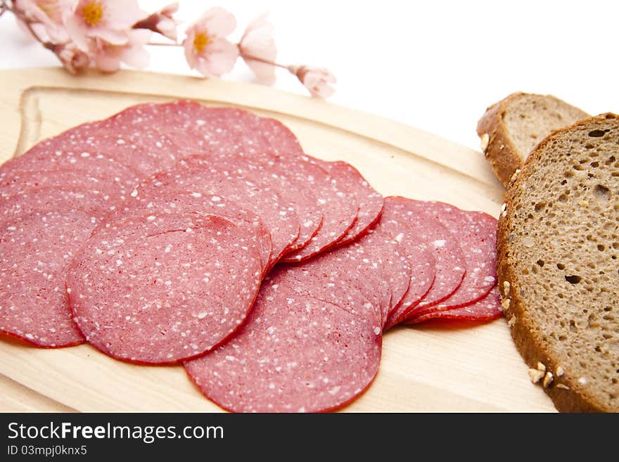 Paprika salami with bread onto white background