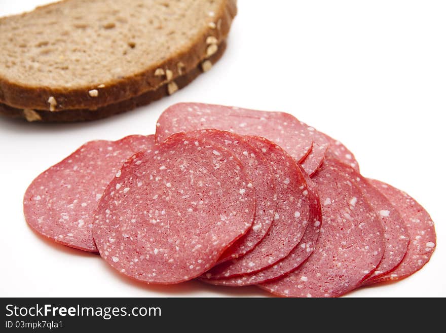 Paprika salami with bread onto white background