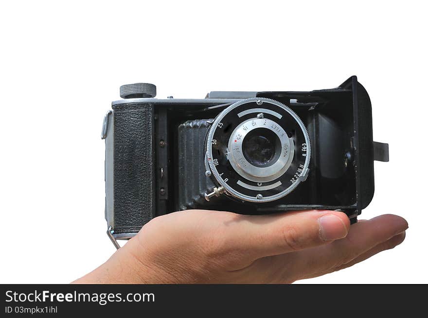 Old camera lies in the palm of the photographer isolated against a white background