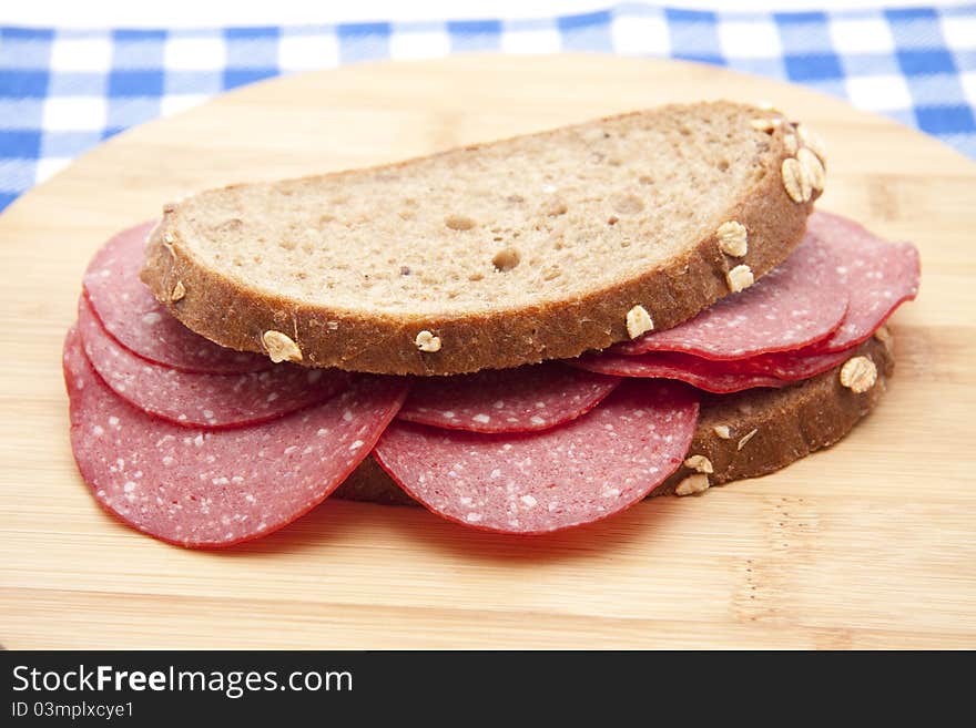 Bread with salamis onto wood plates