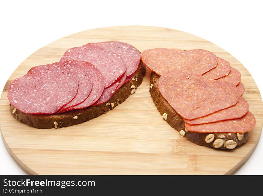 Bread with salamis onto wood plates