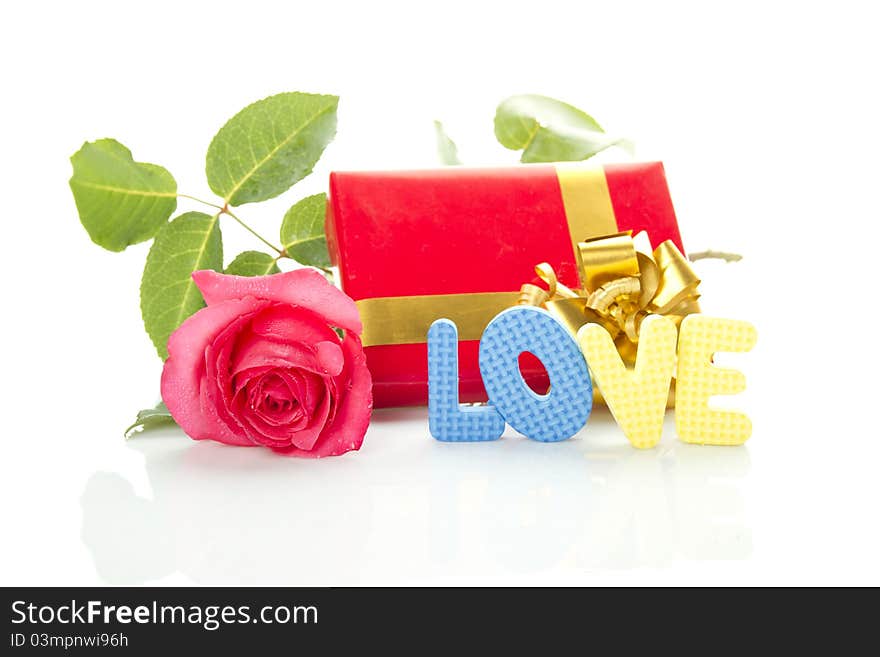 Beautiful red rose, a red gift box and the text LOVE. Isolated on a white background. Beautiful red rose, a red gift box and the text LOVE. Isolated on a white background