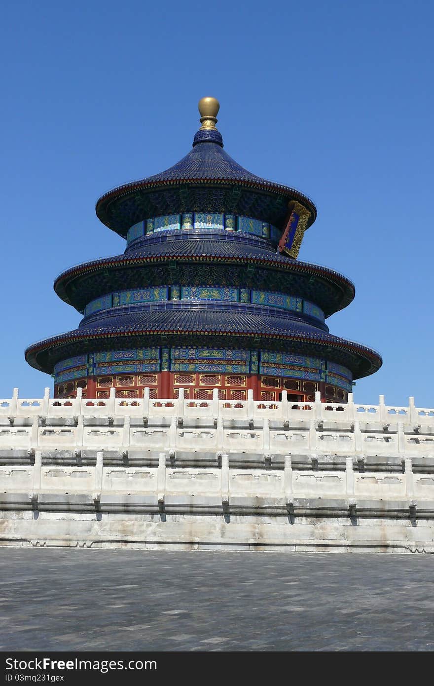 Chinese temple behind white barrier.