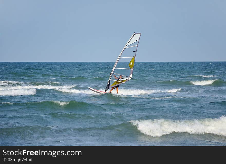 Windsurfer moveing on storm sea. Windsurfer moveing on storm sea