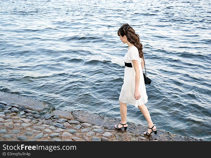 Young beautiful girl on against the background of water