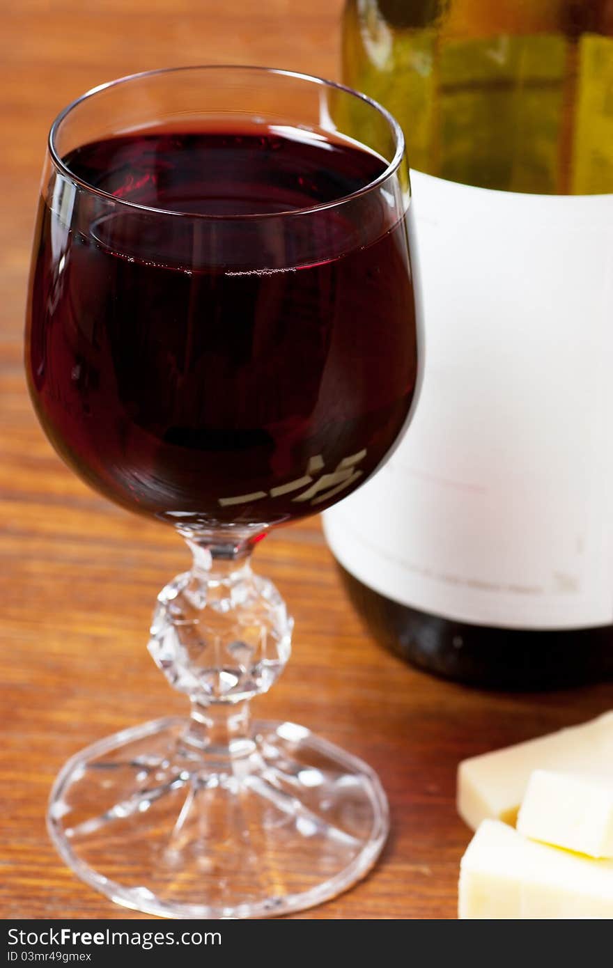 Wine glass and bottle and cheese on a table