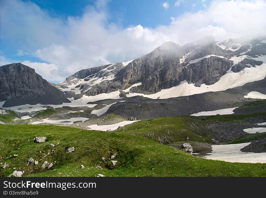 Mountain landscape with snow and clouds