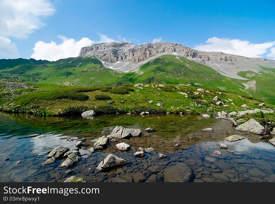 Caucasus mountains and lake with flowers. Caucasus mountains and lake with flowers