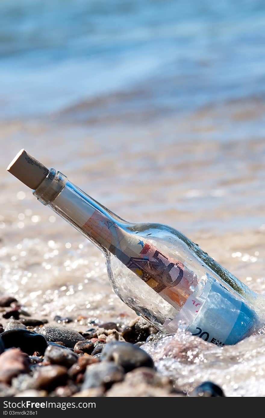 A message in a bottle on the beach fullly with euronotes. A message in a bottle on the beach fullly with euronotes