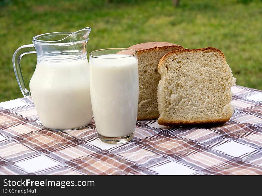 Milk and bread on table in garden. Milk and bread on table in garden