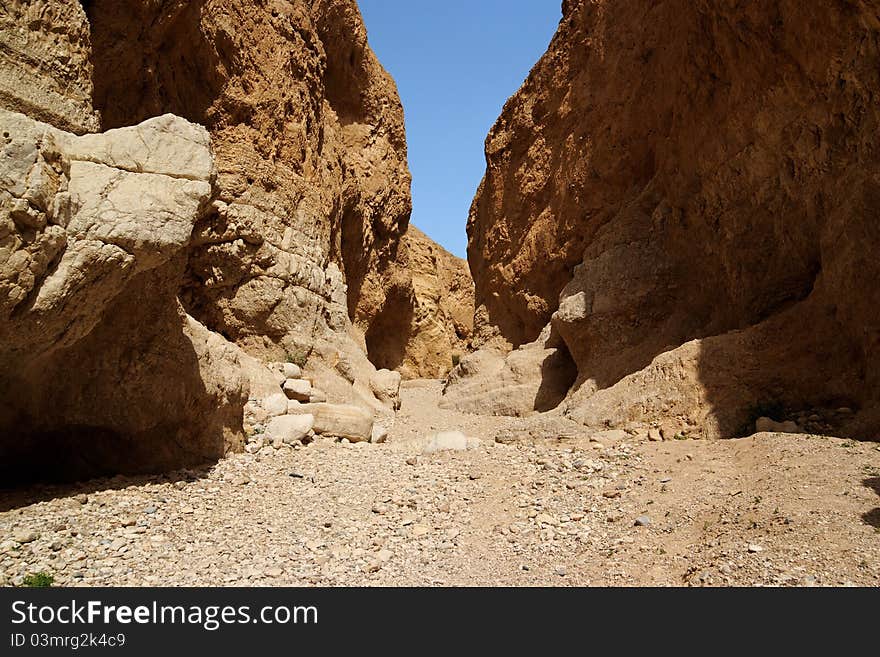 Narrow orange desert canyon with high limestone walls