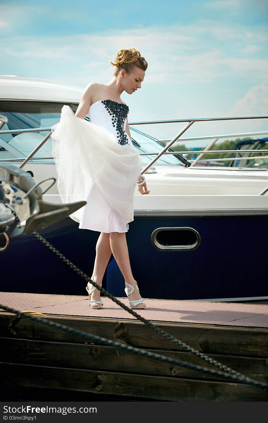 A girl in a summer dress near the boat, sunny day. A girl in a summer dress near the boat, sunny day