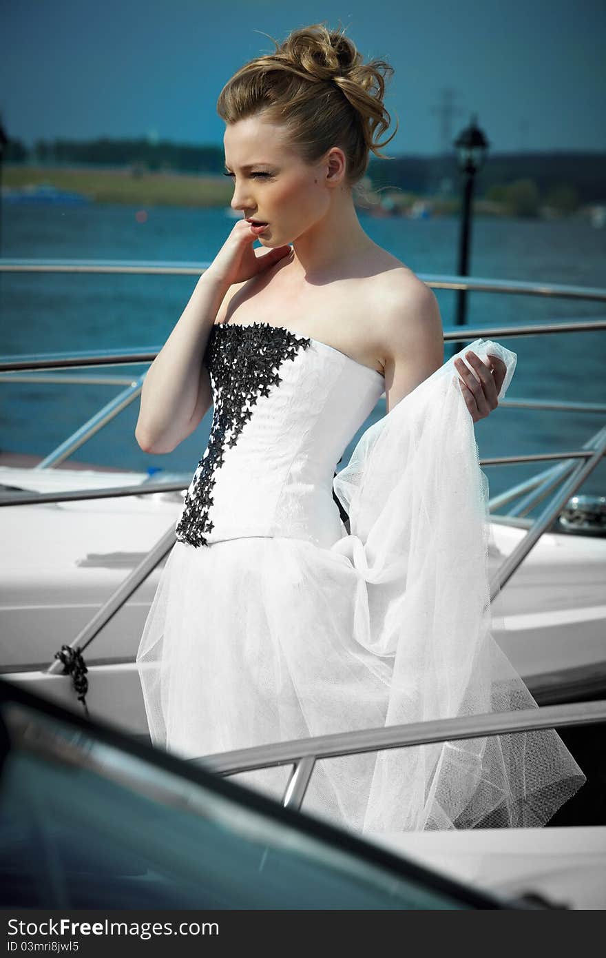 A girl in a summer dress near the boat, sunny day. A girl in a summer dress near the boat, sunny day