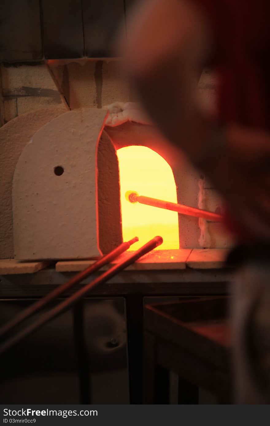 Closeup of a glassblower's working poles - warming up in the hot oven. Closeup of a glassblower's working poles - warming up in the hot oven.