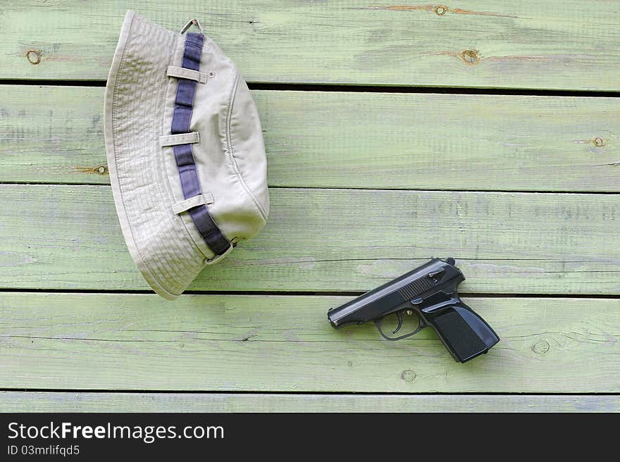 Hat and pistol on shabby wall of the barn. Hat and pistol on shabby wall of the barn