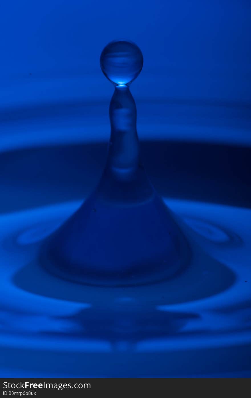 The round transparent drop of water, falls downwards