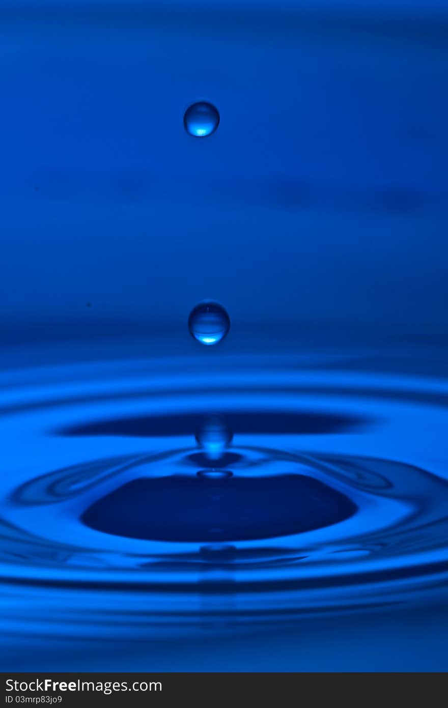 The round transparent drop of water, falls downwards