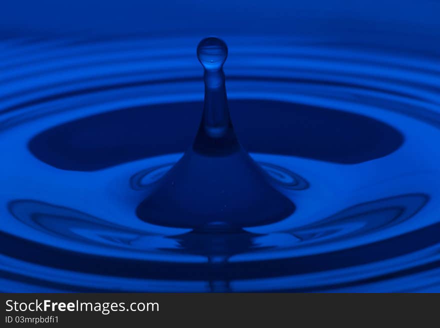 The round transparent drop of water, falls downwards