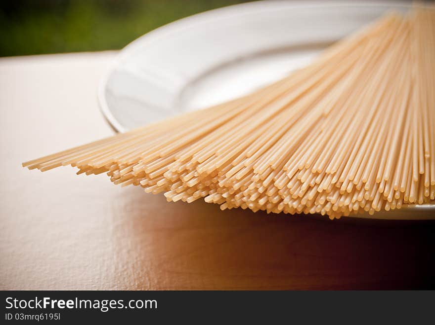 A plate of dried spaghetti pasta shot in natural sunlight