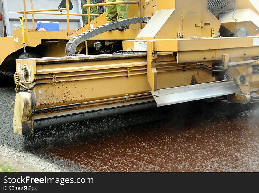 Gravel spreader at work preparing road for re-surfacing