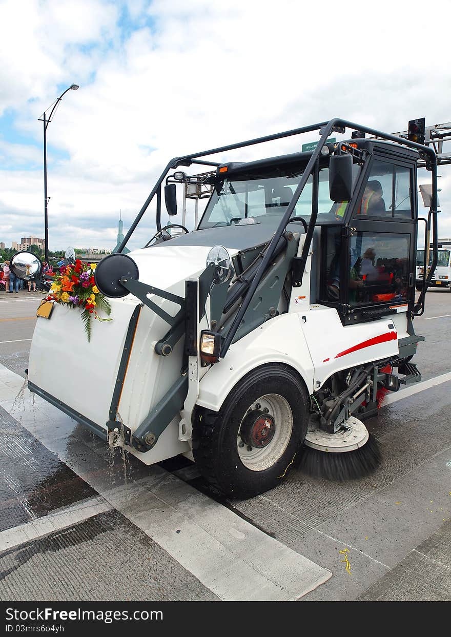 An automated cleaning vehicle sweeping the street after a festival. An automated cleaning vehicle sweeping the street after a festival.