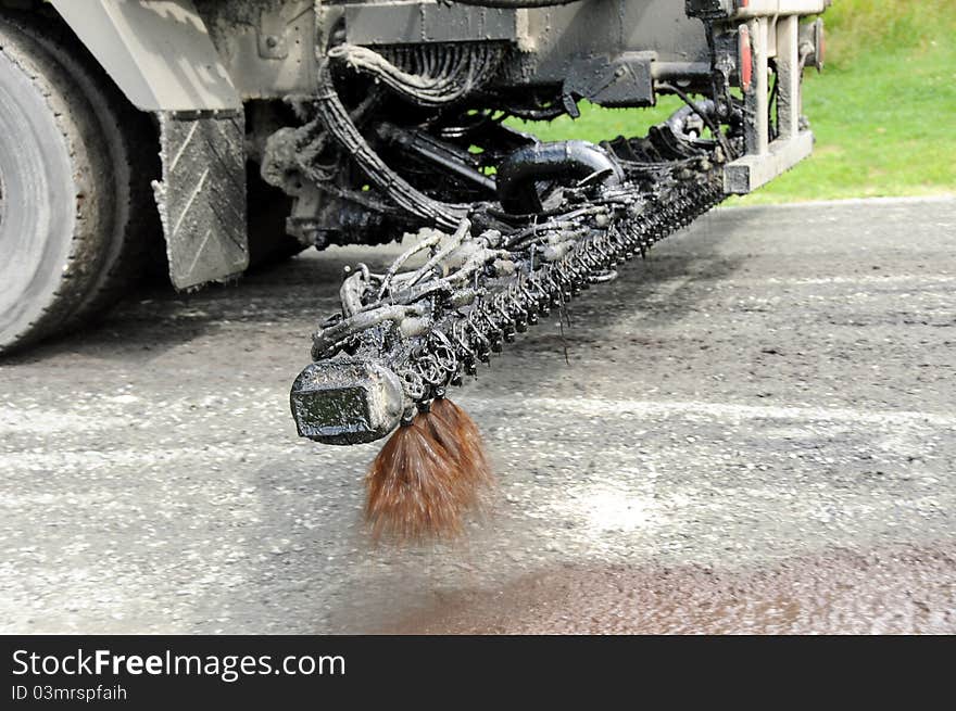 Truck sprays oil on road to prepare it for resurfacing