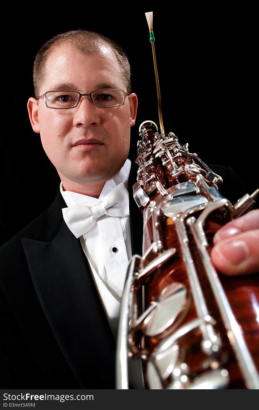 Caucasian male holds his bassoon with a serious expression on his face in the studio. Caucasian male holds his bassoon with a serious expression on his face in the studio.