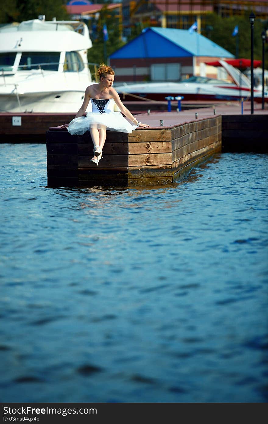 A girl in a summer dress near the boat, sunny day. A girl in a summer dress near the boat, sunny day