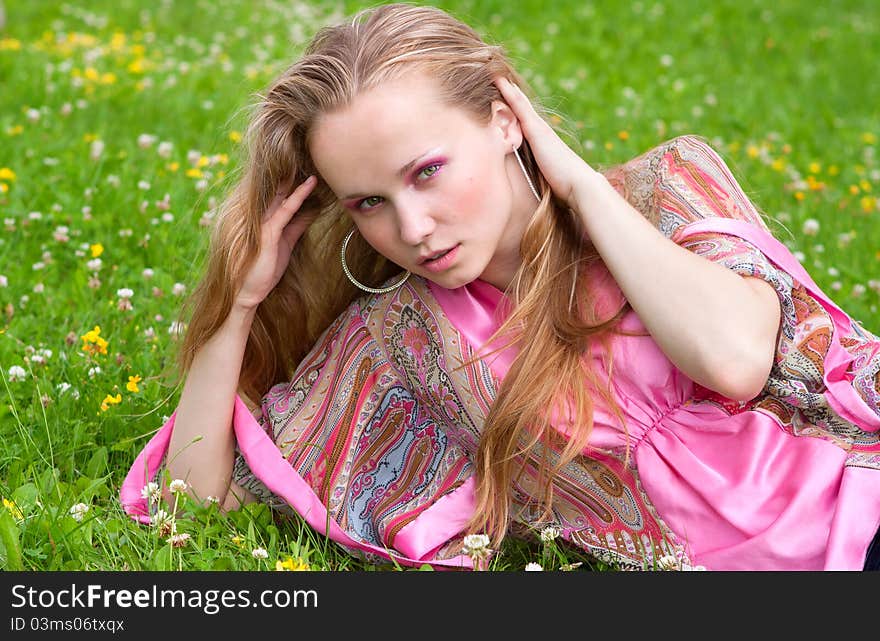 Portrait of a beautiful young woman on the grass in summer. Portrait of a beautiful young woman on the grass in summer