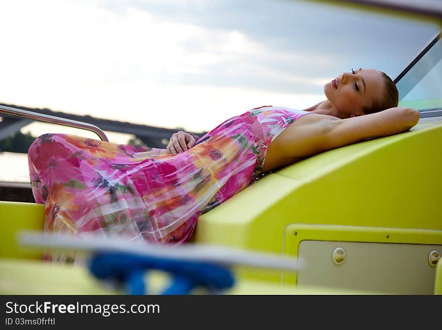 A girl in a summer dress near the boat, sunny day. A girl in a summer dress near the boat, sunny day