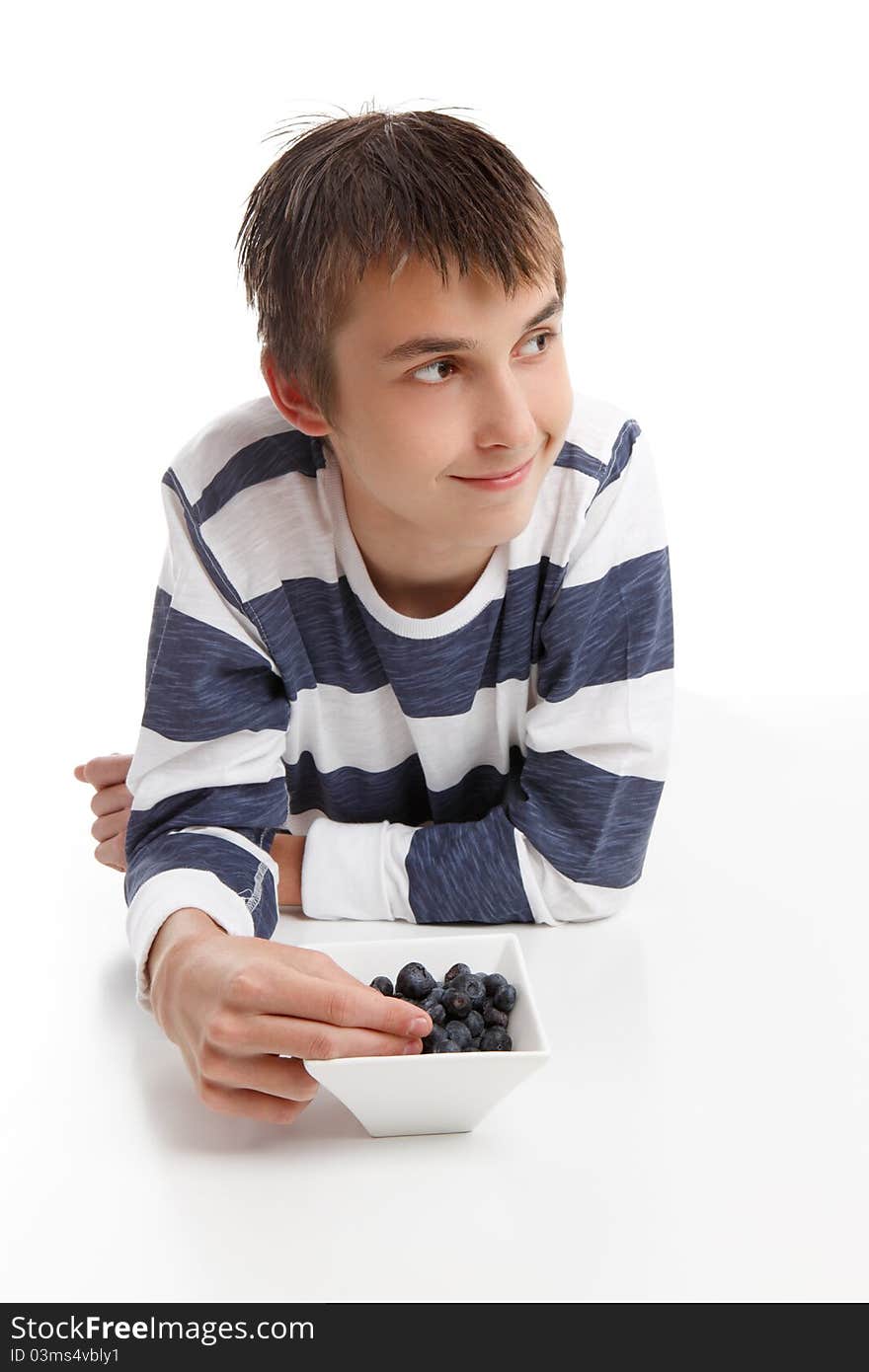 Boy with a bowl of berries. He is looking sideways, suitable for message. White background. Boy with a bowl of berries. He is looking sideways, suitable for message. White background.