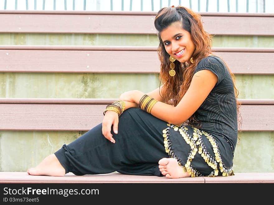 A young Pakistani model wearing gold traditional outfit and gold jewellery and posing. A young Pakistani model wearing gold traditional outfit and gold jewellery and posing