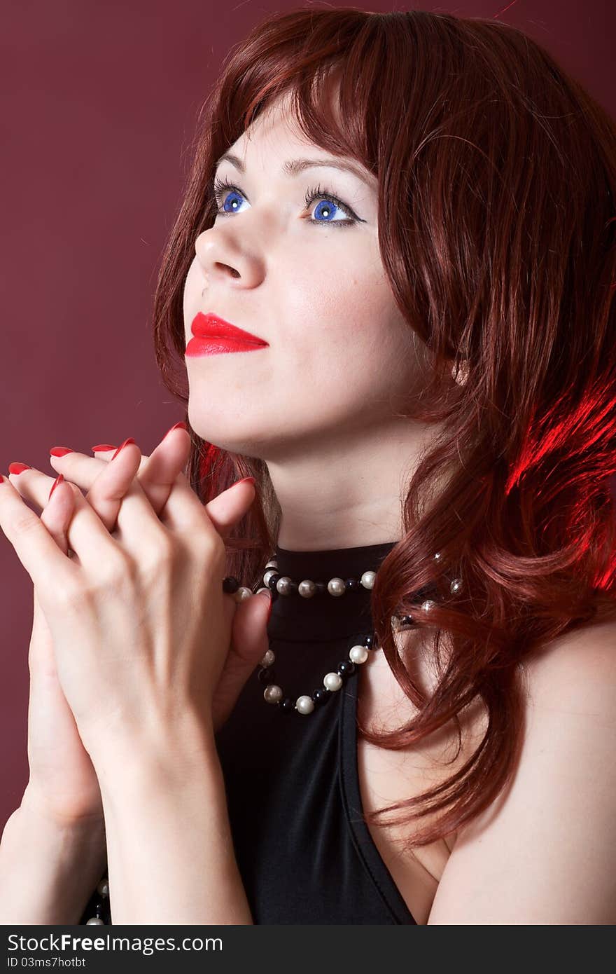 Praying woman on red burgundy background