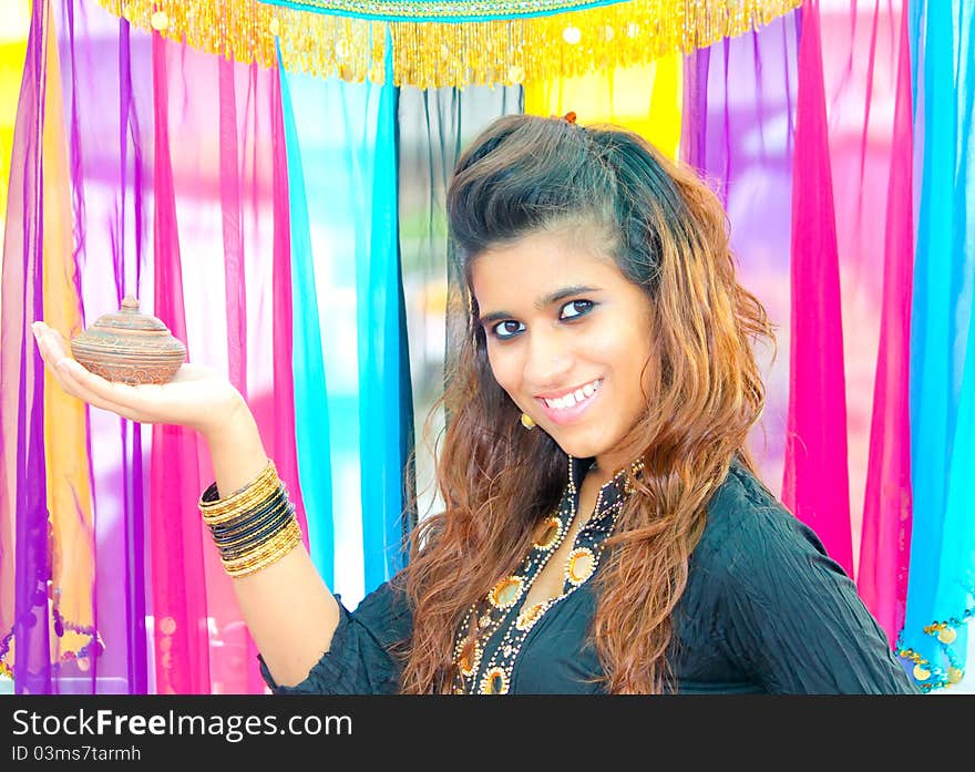 Young Pakistani model holding a traditional indian lamp on her hands. Young Pakistani model holding a traditional indian lamp on her hands