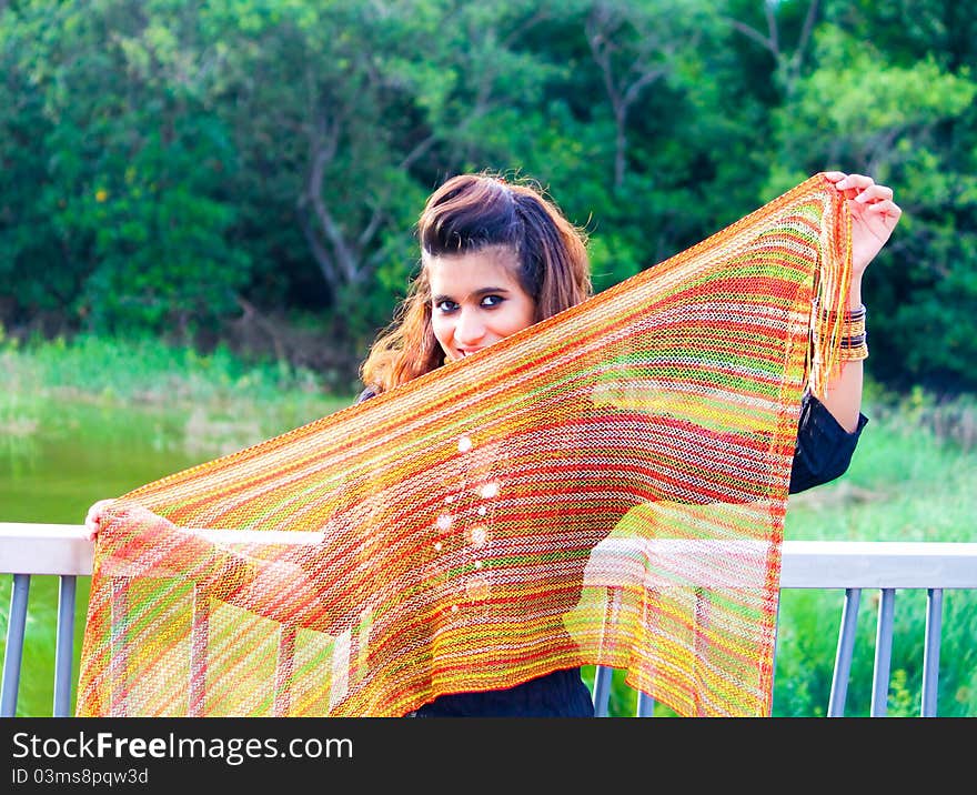 A young Pakistani model holding a traditional indian scarf and posing in the outdoors. A young Pakistani model holding a traditional indian scarf and posing in the outdoors.