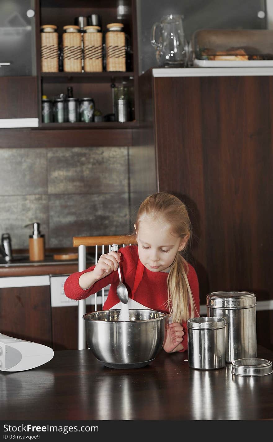 The little girl is cooking. The little girl is cooking