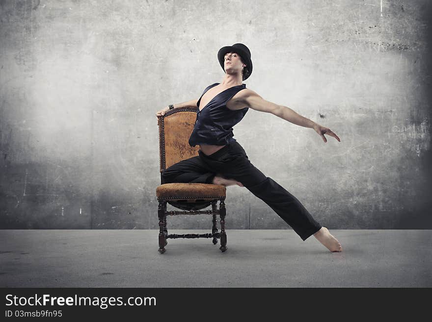 Young man dancing on an old chair. Young man dancing on an old chair