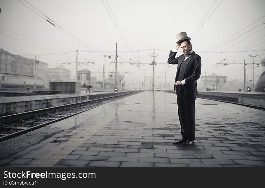 Gentleman standing on the platform of a train station. Gentleman standing on the platform of a train station