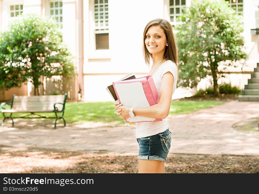 A pretty young college or high school age girl with study materials. A pretty young college or high school age girl with study materials