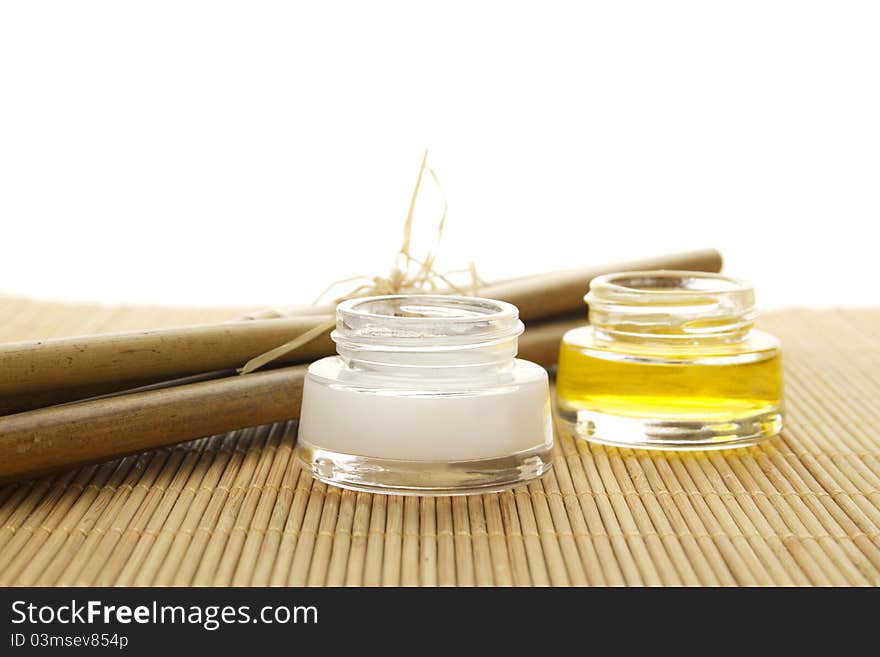 Two cans of cream and bamboo sticks on a wooden mat. Two cans of cream and bamboo sticks on a wooden mat