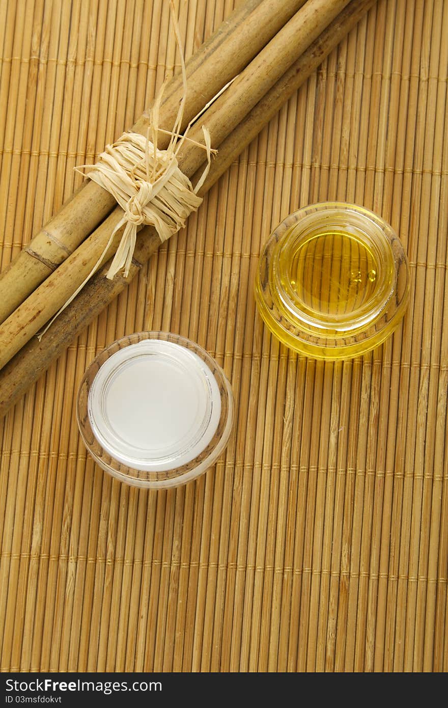 Two cans of cream and bamboo sticks on a wooden mat. Two cans of cream and bamboo sticks on a wooden mat