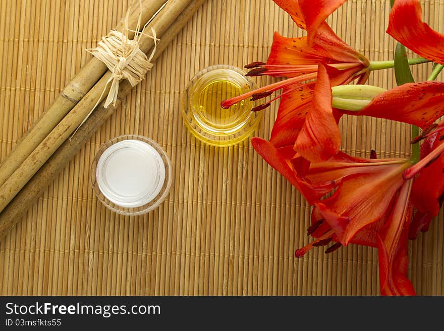 Two cans of cream flowers and bamboo sticks on a wooden mat. Two cans of cream flowers and bamboo sticks on a wooden mat